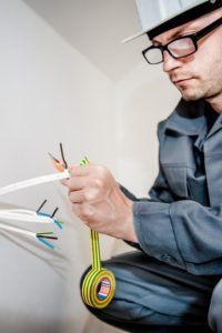 Eletrotécnico consertando cabos elétricos