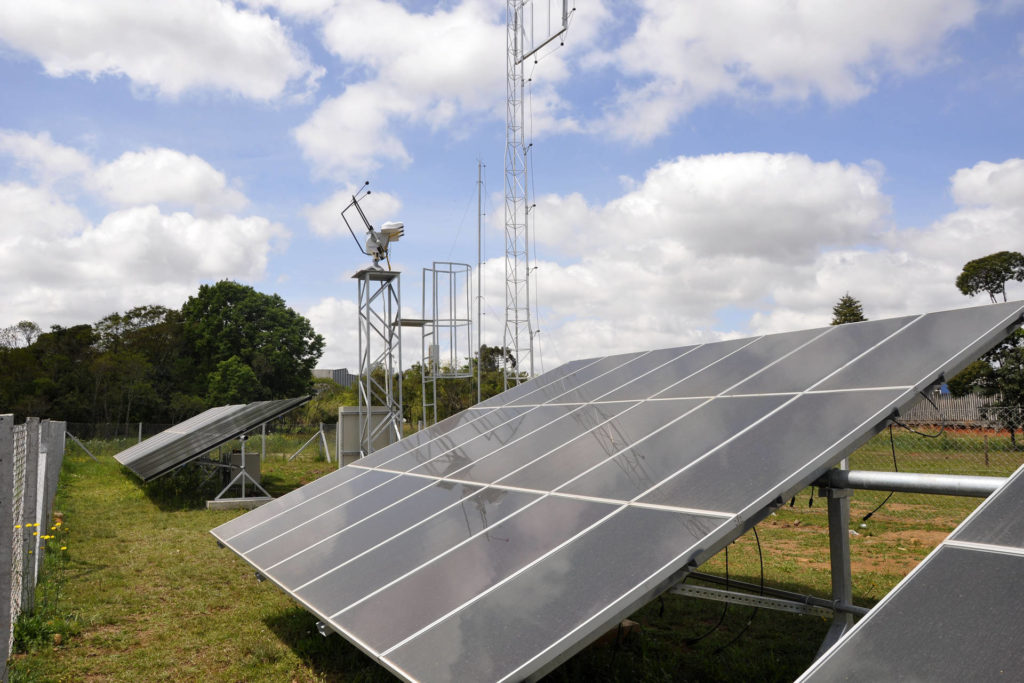 painel solar instalado em gramado com fundo de céu azul e nuvens