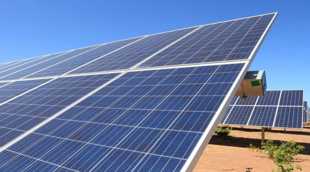 Foto de baixo para cima de placa solar com céu azul ao fundo